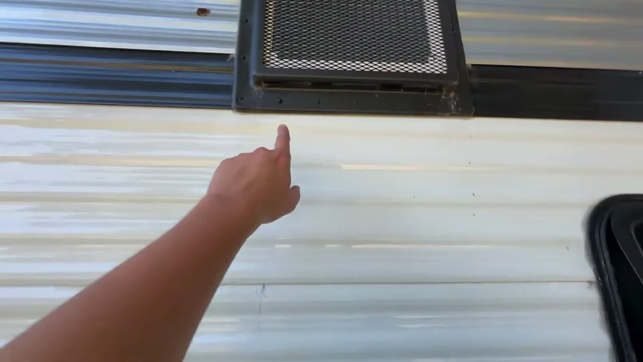 Pointing to where the air conditioner drains down the side of a Coleman 17B