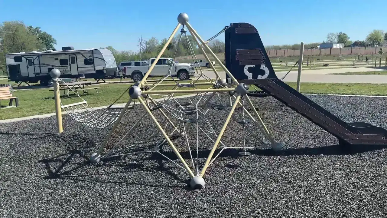 Playground with a climbing net and slide next to campsites at Fontana County Park in Hazleton, Iowa
