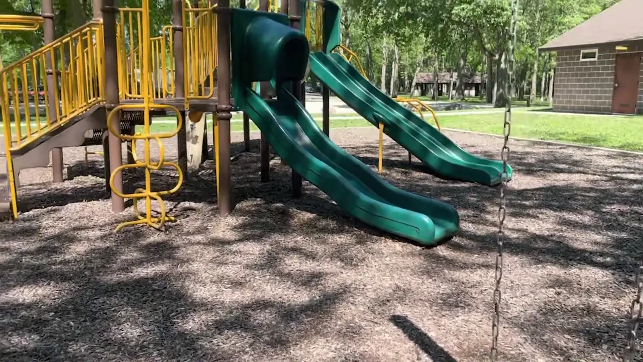 Playground with green slides and yellow climbing bars near the dam at Heery Woods State Park