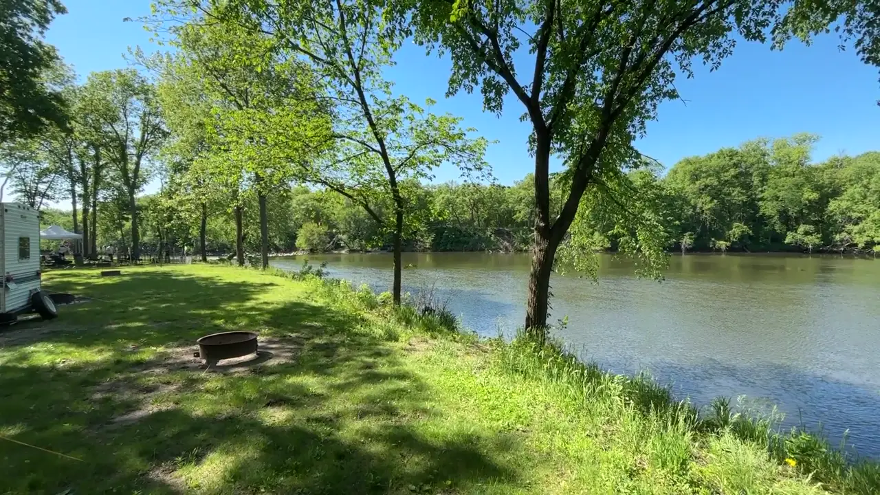 Grassy riverside campsite with a fire ring on the Shell Rock River at Heery Woods State Park in Clarksville, Iowa