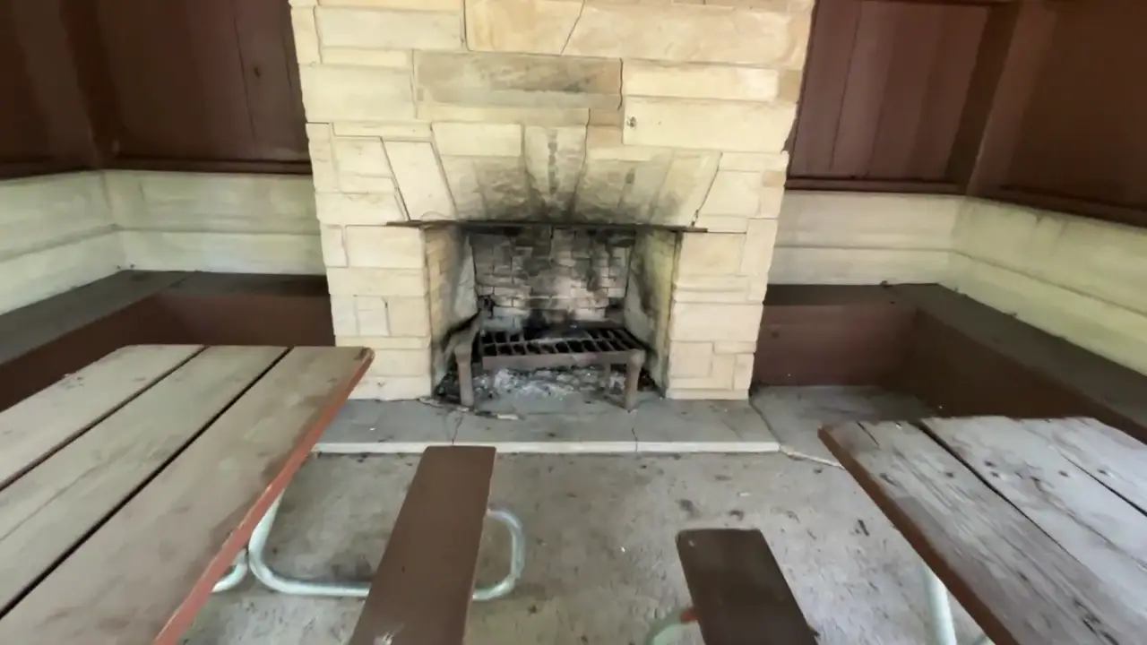 Stone fireplace and picnic tables inside the shelter house at Heery Woods State Park