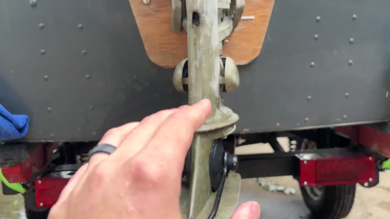 Pointing to the water intake on the lower unit of a used outboard